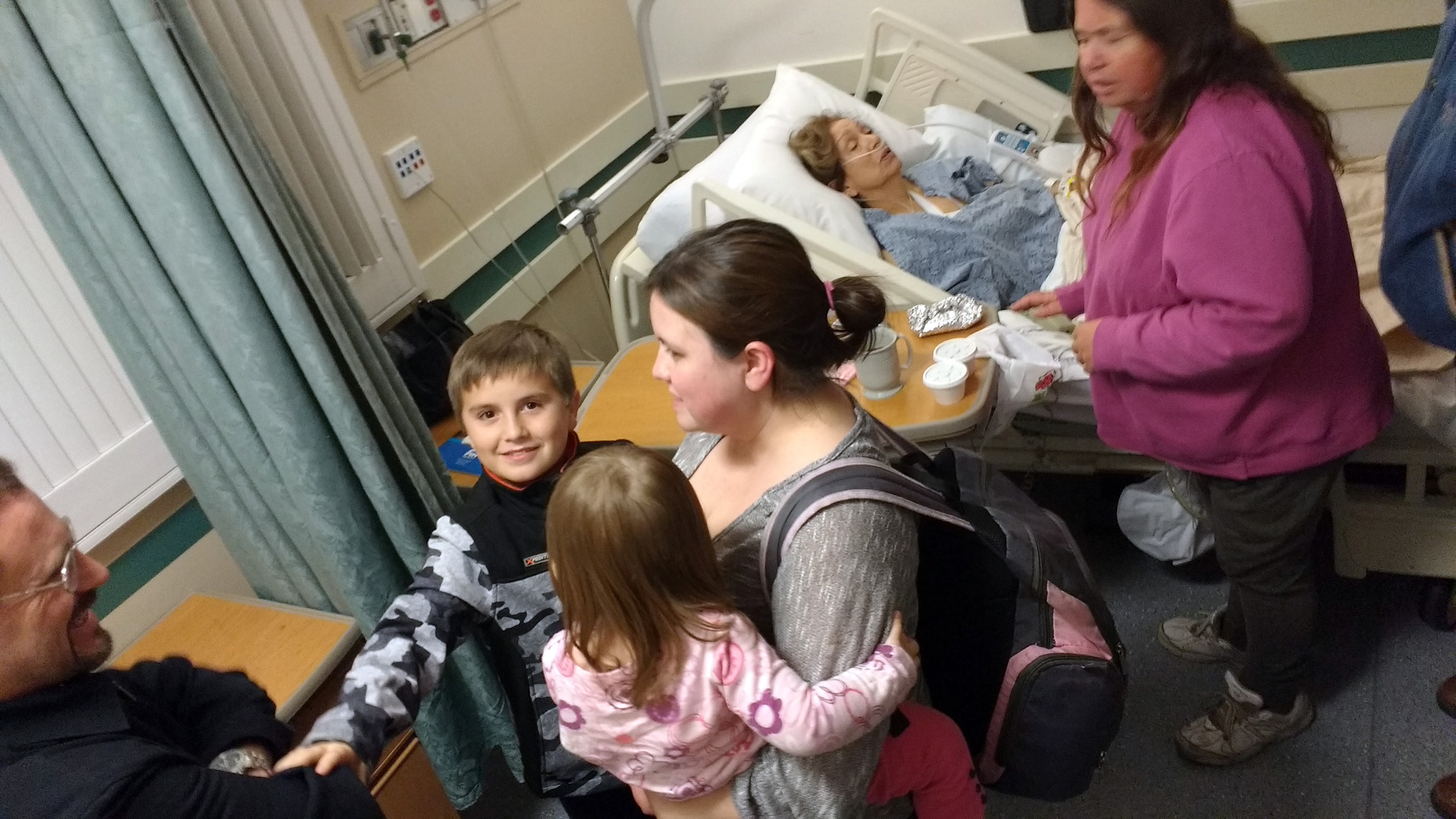 visitors around a hospital bed